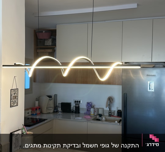 מטבח עם תאורה תלויה מודרנית מעל השיש